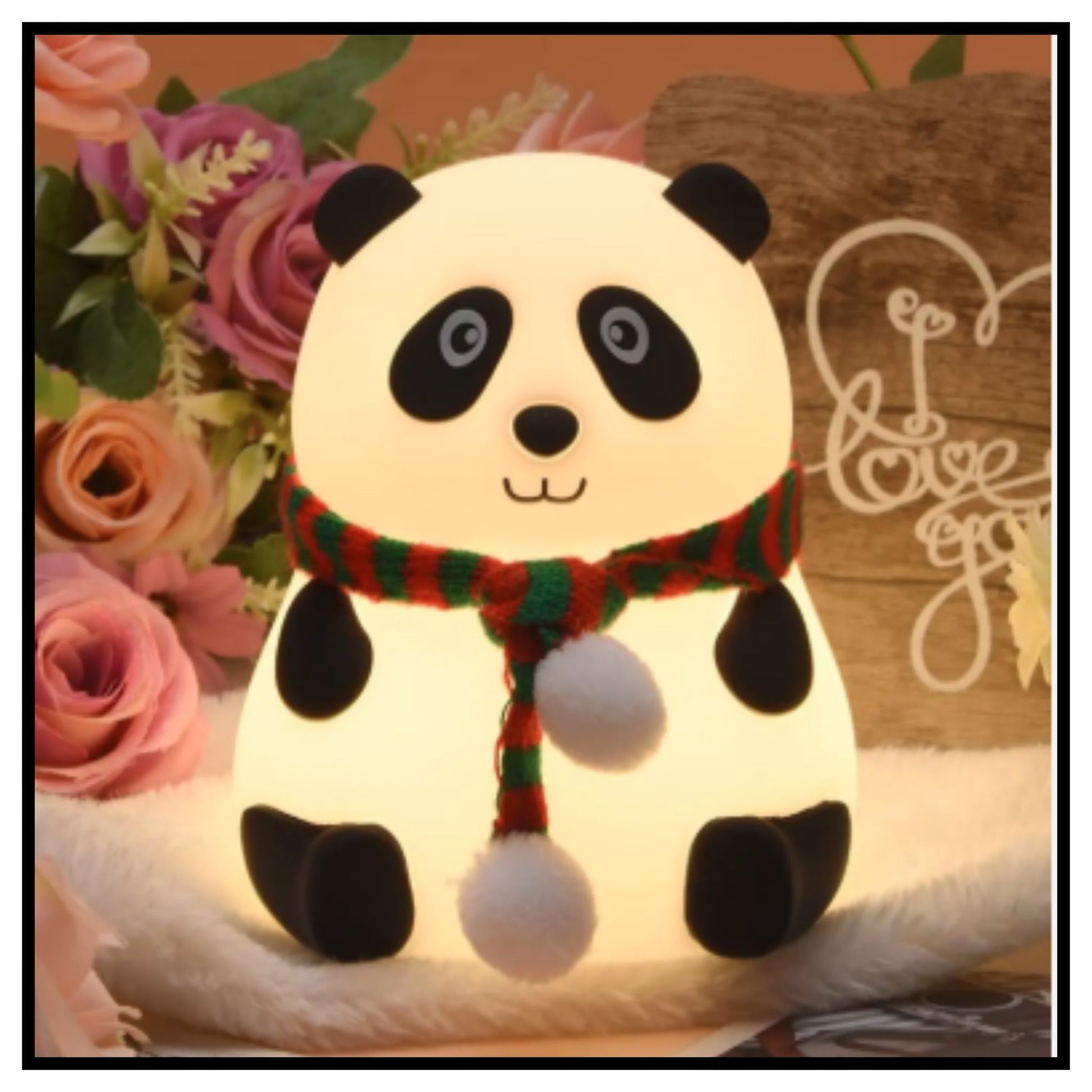 Cute panda silicone night lamp with red and black scarf held in hand with warm yellow glow